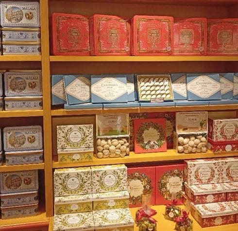 Inside La Cure Gourmande Malaga showing products on the shelfs of a traditional confectionary shop.
